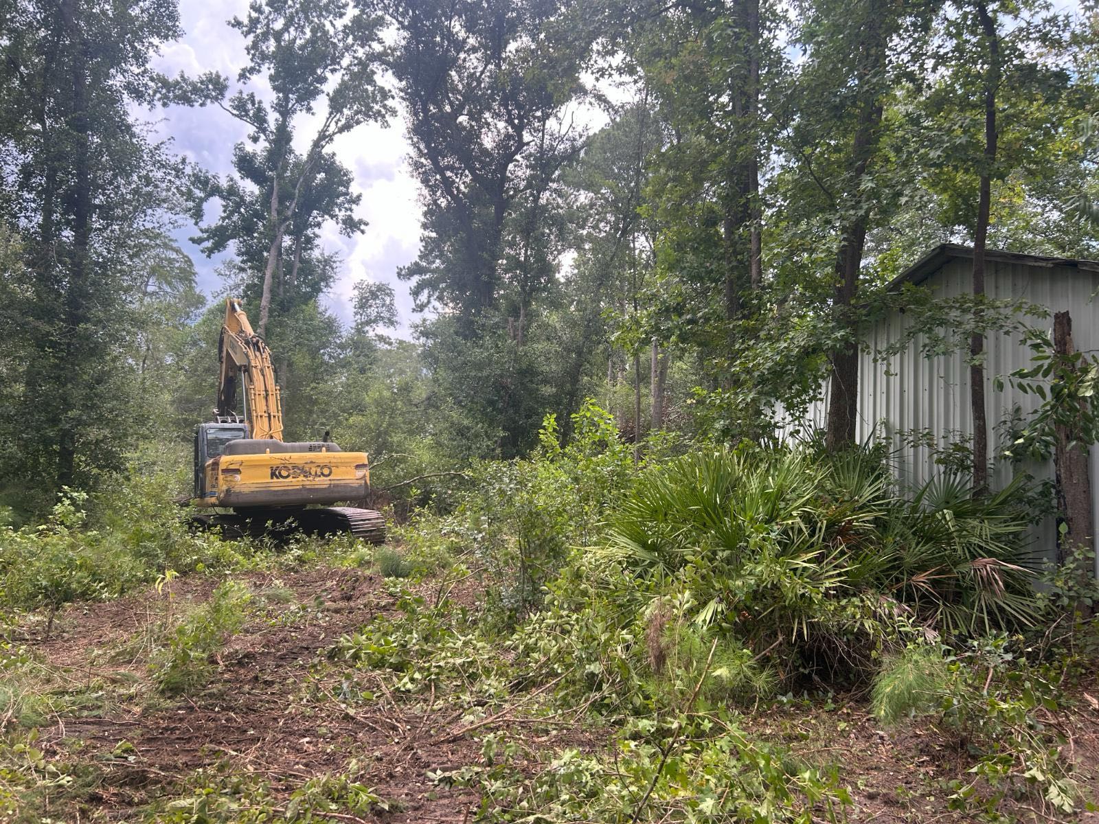 Excavator working beside an outbuilding