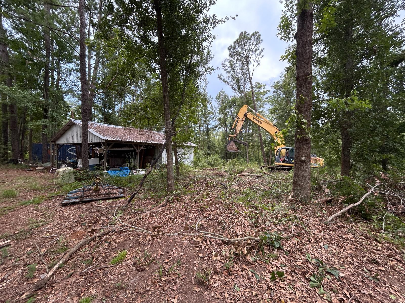 Brad King's excavator working beside an old barn